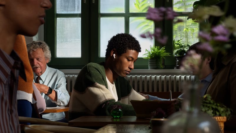 Apple's AirPods 5 Bring Open-Ear ANC and Siri AI to All 2 Apple AirPods 5 active noise cancellation earbuds resting beside their charging case