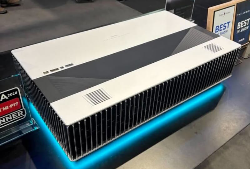 AWOL LuxVision projector sitting beneath a large screen showing a vivid 4K image