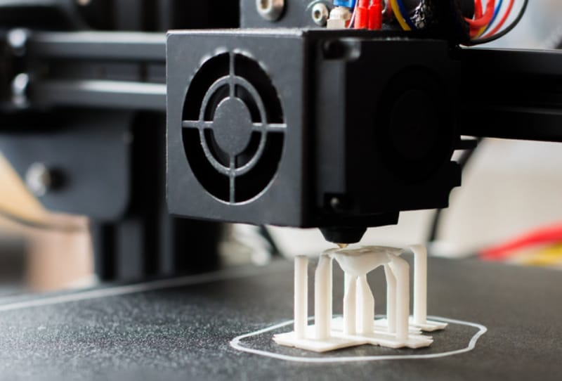 A 3D printer running on a desk in a home office, illustrating 3D printer bedroom safety concerns around ventilation