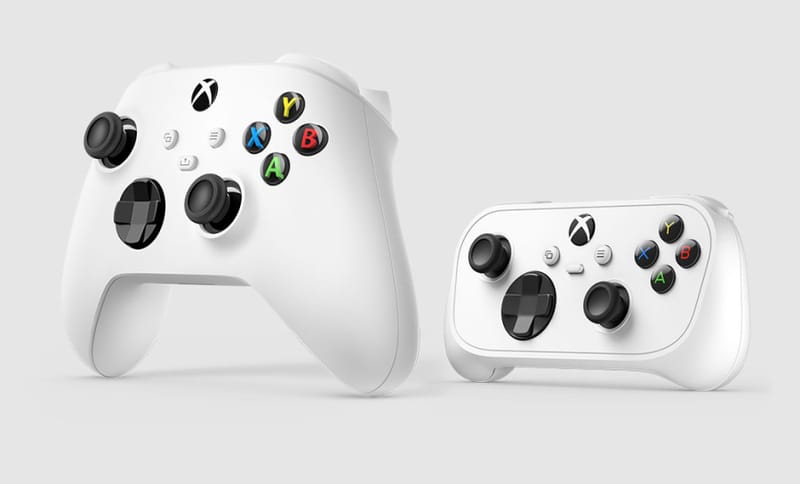 Xbox Nano controller held in one hand next to a smartphone to show its pocket-size footprint
